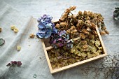 Dried flowers in wooden crate on linen cloth