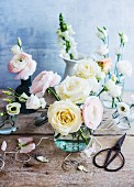 Glass vase of pale pastel roses and ranunculus