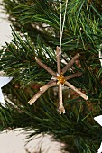 Star made from twigs hanging on Christmas tree