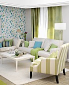 Upholstered furniture and patterned wallpaper in classic living room in white, blue and green
