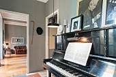 Klavier mit Notenheft in grau gestrichenem Musikzimmer