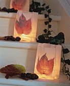 Paper-bag candles lanterns decorated with autumn leaves