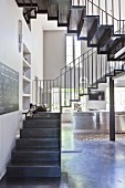 Delicate metal staircase in loft apartment in shades of grey
