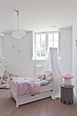 Free-standing bed with canopy in vintage-style child's bedroom