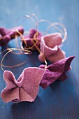 Pieces of felt in berry shades tied with copper wire