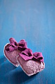 Hand-sewn felt hearts with bows on blue surface