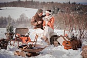 Man and woman enjoying a winter picnic in a snowy landscape