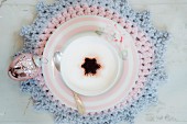 Cup of cappuccino on crocheted doily
