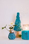 Christmas arrangement of turquoise needlework and small hellebore plant