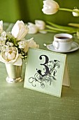 Decorative place card with number 3 on festive table