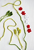 Red and white crocheted flowers and green crocheted cord