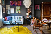 Eclectic furnishings and pictures on grey wall in living room