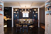 Symmetrical ornaments in dark blue fitted shelves in open-plan eclectic dining area