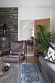 Retro leather armchair in front of fireplace in rustic living room