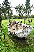 Rustic sailing dinghy on lawn used as sandpit