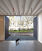 Minimalistischer Wohnraum mit Betonboden und Terrassentür