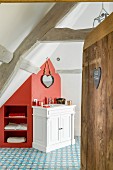 Attic bathroom with shelves integrated into red section of wall