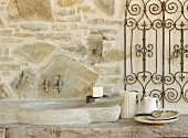 Stone sink and taps mounted on stone wall on terrace