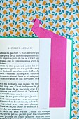 Pink origami bookmark on page of open book