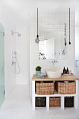Gefliester Waschtisch mit Aufbewahrungskörben und Aufsatzbecken, Blick in barrierefreien Duschbereich