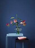 Eleganter, tropischer Blumenstrauss aus Gloriosa und Mini-Anthurie in einer Bauchvase