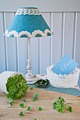 Lampshade decorated with paper doily between lace baskets