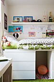 Loft bed on top of chest of drawers in child's bedroom