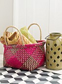 Colourful wicker basket next to ceramic candle lantern