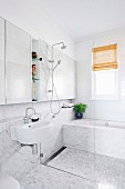 Bright bathroom with a barrier-free shower area in front of the bathtub