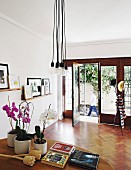 Coat stand on exotic-wood parquet floor and framed pictures on narrow shelves in elegant foyer