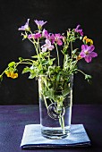 Small bunch of wild flowers in glass of water