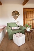 Romantic pattern of roses on hand-sewn, loose pouffe cover and bolster on armchair