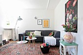 White crocheted blanket and scatter cushions on grey couch in retro living room