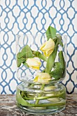 Gelbe Tulpen in Glasvase ausgelegt