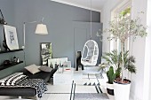 Modernes Wohnzimmer in Grautönen, mit Tagesbett, Hängestuhl, Wandleuchte und Pflanzen