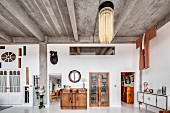 Concrete ceiling, glass wall and eclectic furnishings in loft apartment