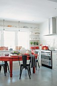 Red dining table and metal chairs in kitchen