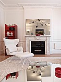 Classic, white leather armchair, matching footstool and set of mirrored coffee tables in traditional interior with modern ambiance