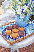 Muffins and a summery bouquet of flowers on a tray with a homemade fabric cloth