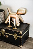Gold dog figurine and candles on antique miniature trunk with brass latches
