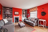 Elegant living room with red walls, fitted shelving and open fireplace