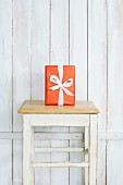 Gift on stool against white board wall