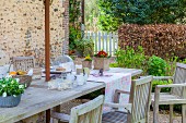 Garden table set with spring flowers and wooden chairs on rustic terrace
