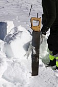 Cutting snow blocks with a saw