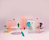 An arrangement of garden furniture and accessories in a pastel coloured studio