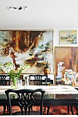 Dining table in front of large paintings on wall