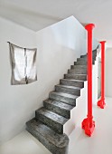 Concrete staircase next to red steel column