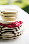 Stack of plates, bowls and napkins on garden table