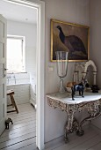 Exquisite antique console table with marble top below painting of bird