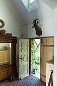 Antique wooden doors and hunting trophy in renovated country house